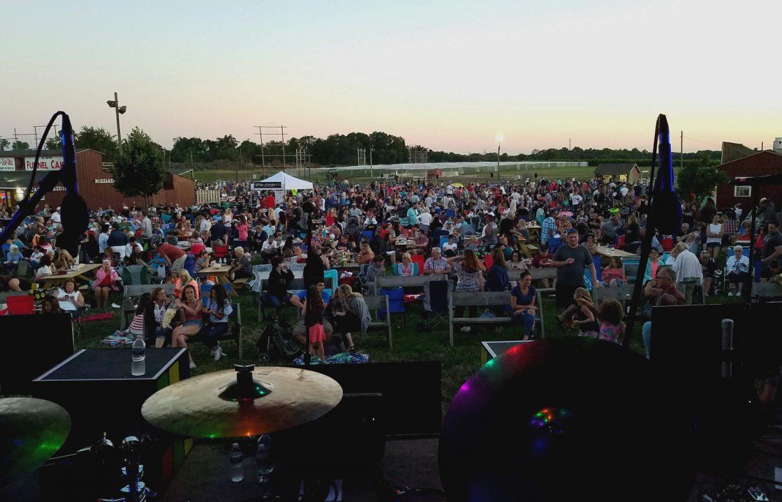 On stage shot from behind a drum kit looking at a large festival crowd